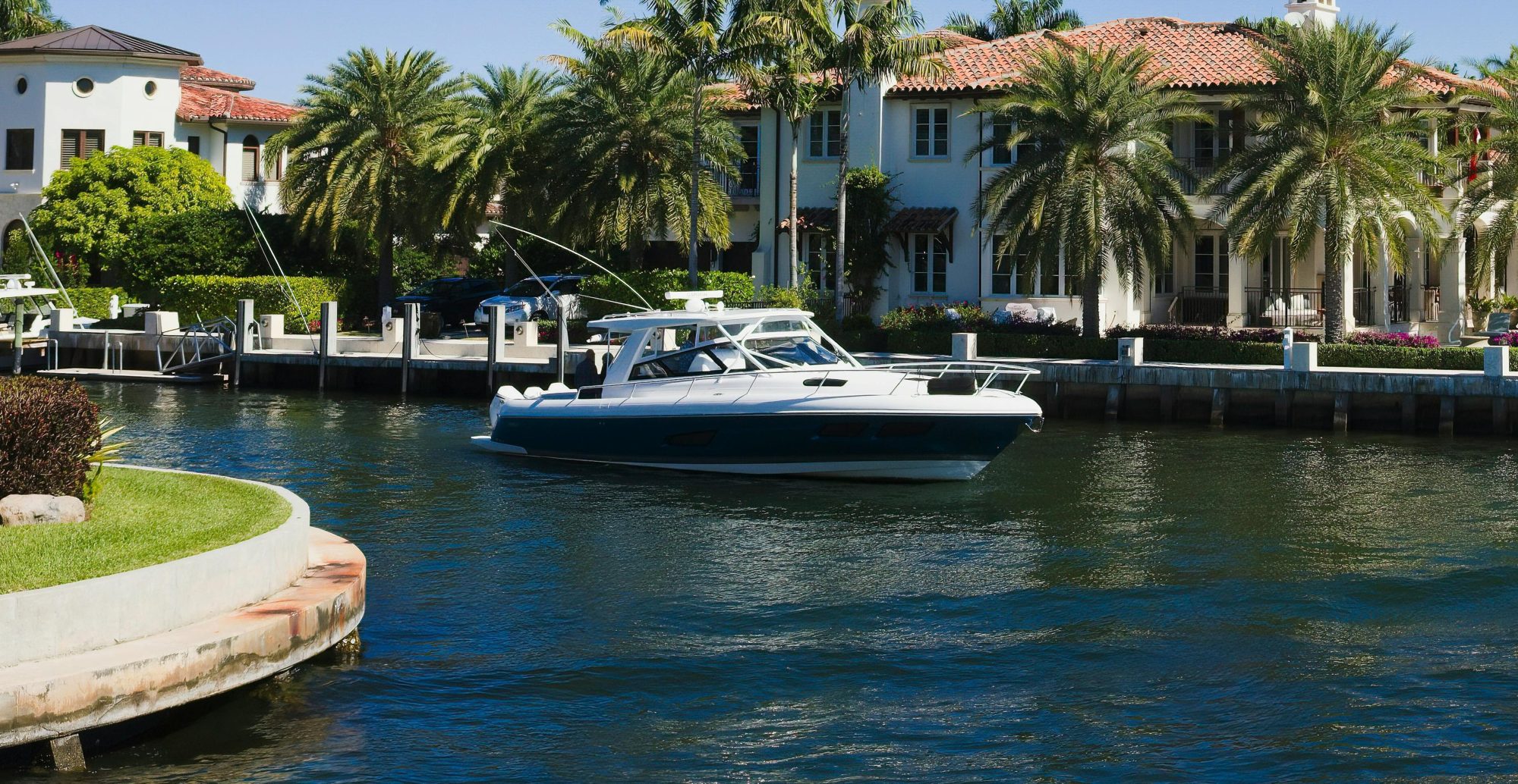 A motor yacht cruising the Las Olas canals past waterfront homes